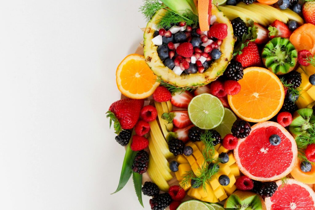 pexels-photo-1128678-1128678-1 Colorful flat lay of assorted tropical fruits including pineapple, berries, and citrus.